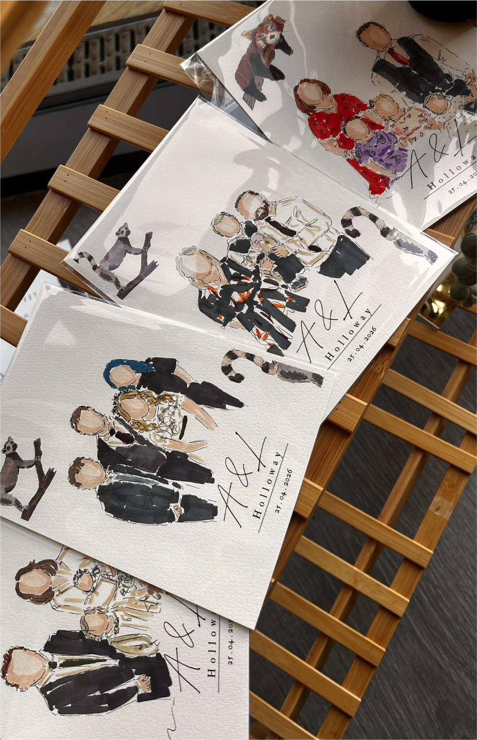 Multiple completed hand-painted portraits laid out on a wooden surface